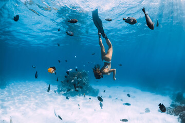 Beauty freediver woman dive in ocean with fishes in tropics
