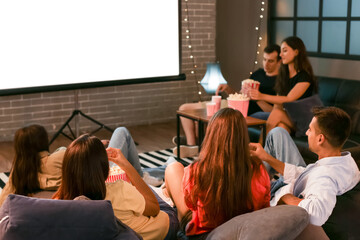 Group of friends watching movie at home in evening
