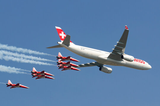 Payerne, Switzerland - September 6, 2014: Swiss International Air Lines Airbus A330 aircraft flying in formation with Northrop F-5 aircraft of Patrouille Suisse display team from the Swiss Air Force.