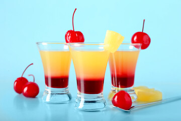 Tasty Pineapple Upside Down Cake Shots on blue background, closeup