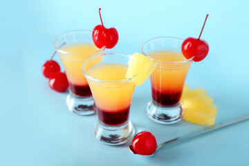 Tasty Pineapple Upside Down Cake Shots on blue background, closeup