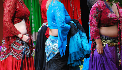 Fototapeta premium Bellydancers in colorful costumes on stage outdoors.