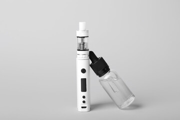 Modern vape mod and oil on light background