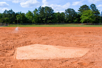 Home plate with faded chalk lines on the infield of a baseball - softball diamond