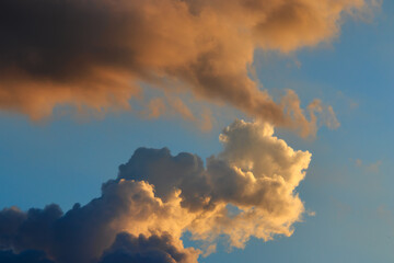 clouds shaded in various shades of orange, blown by the winds under the twilight sky.