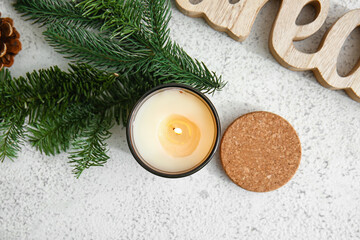 Holder with burning candle and fir branch on light background