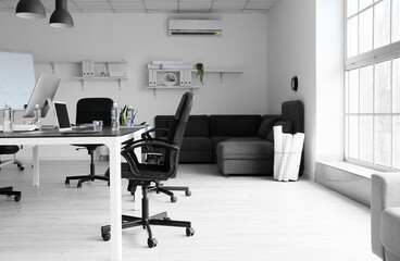 Table with modern computers and bottles of water in conference room interior