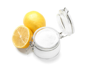 Glass jar with baking soda and ripe lemons on white background