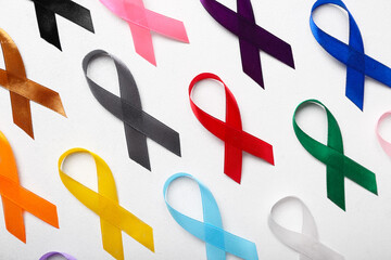 Set of different awareness ribbons on light background, closeup. World Cancer Day