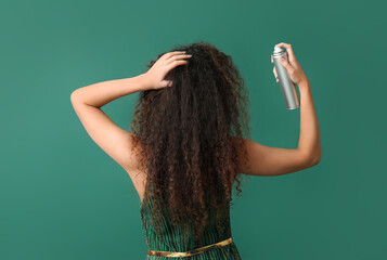 Pretty young African-American woman with hair spray on green background, back view - obrazy, fototapety, plakaty