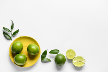 Plate with fresh juicy limes on light background