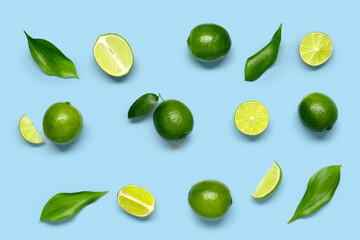 Composition with juicy limes and leaves on blue background
