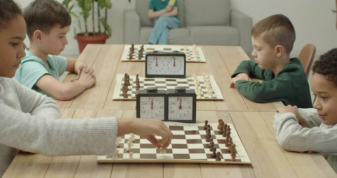 Little children playing chess during tournament in club
