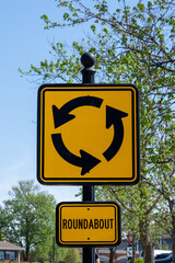 yellow and black roundabout traffic sign