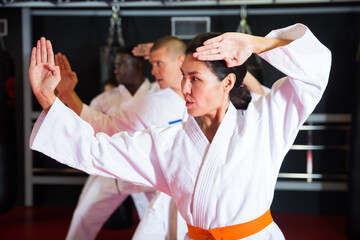 People practicing taekwondo and warming up for training while standing barefoot