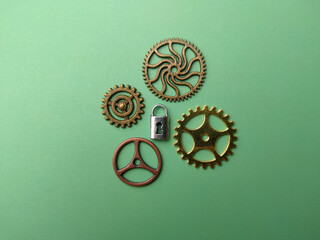 Silver padlock Mixed Gear Cog DIY Craft gold and bronze on a soft green background.