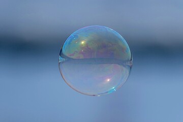 ブルーバックに飛ぶ幻想的な模様のシャボン玉