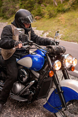 Obraz na płótnie Canvas Guy riding retro cruiser motorcycle on mountain road in South tyrol