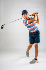 Young male golfer swinging his club