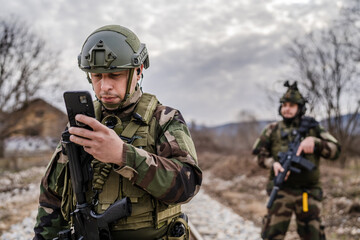 Two soldiers dogs of war mercenaries men in uniform armed service rifles standing while securing...