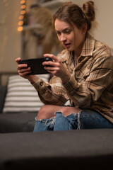 Video games on a portable game console. Girl gamer holds a game console in her hands. Fun pastime,...