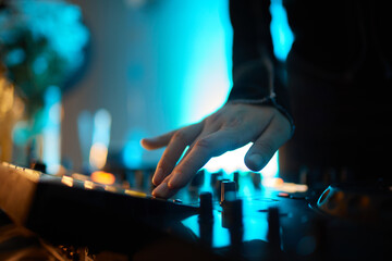Hands of female Dj playing music on modern midi controller turntable. Digital device for mixing...