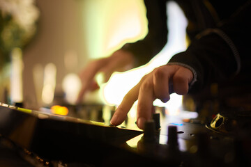Hands of female Dj playing music on modern midi controller turntable. Digital device for mixing...