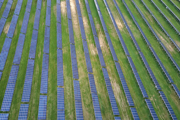 Aerial view of big sustainable electric power plant with many rows of solar photovoltaic panels for producing clean ecological electrical energy. Renewable electricity with zero emission concept