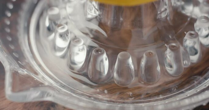 Lemon healthy juice in glass squeezer hand squeezes in macro close up