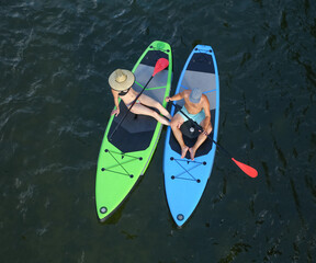 two people sitting on stand up paddle boards from a top overhead view