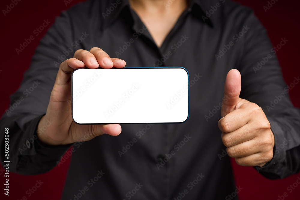 Poster hand holding a horizontal mobile phone with a blank white screen and showing thumbs up while standin