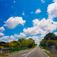 Asphalt road under cloudy blue sky