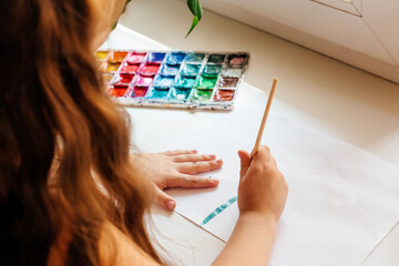 Little girl drawing a mother's day greeting card. Mothers day concept. Happy birthday card. Selective focus