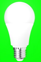 White energy saving light bulb on isolated green background