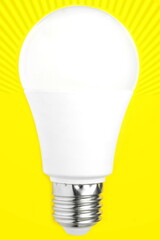 White energy saving light bulb on isolated yellow background with wave of rays