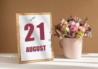 august 21. 21th day of month, calendar date.Bouquet of dead wood in pink mug on desktop.Cork board...