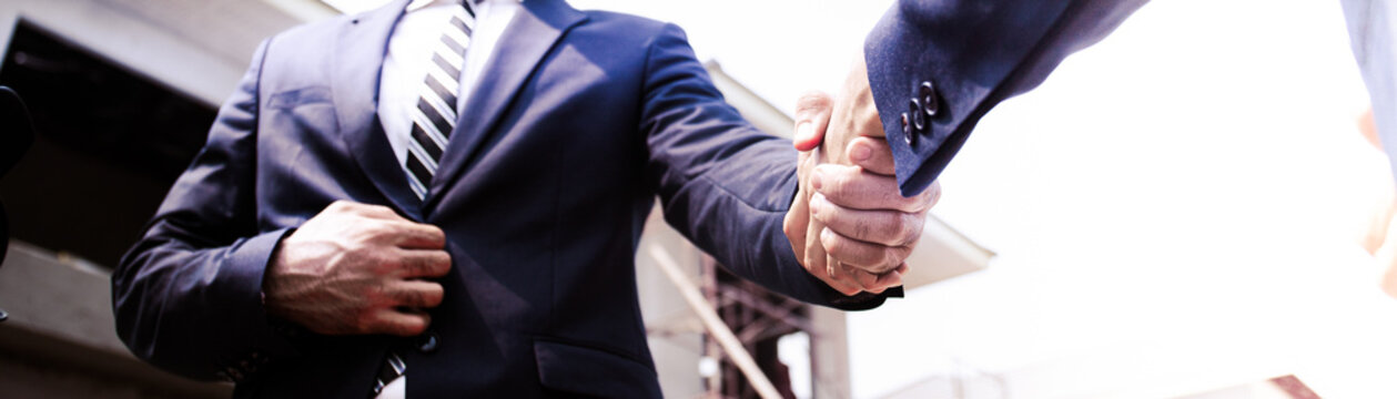 Business Shaking Hands,project Finishing Up Meeting. Successful Businessmen Handshaking After Good Deal.Manager In Formal Suit In Under Construction Site.banner Cover Design.