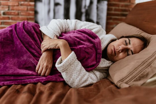Hispanic senior woman sleeping on bed at home in Mexico Latin America