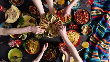 Mexican family celebrates Cinco de mayo. A taco is a traditional Mexican dish consisting of a small corn tortilla topped with a filling