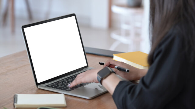 Cropped image of female office worker using laptop computer. Empty screen for advertising text.
