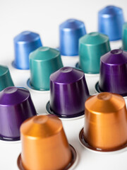 many aluminum coffee capsules are displayed in a row on a white background. Food pattern. Capsules for the coffee machine