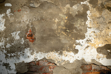 An old wall with fragments of cracked bricks and plaster. Background image