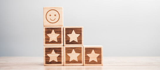 emotion face and Star symbol blocks on table background. Service rating, ranking, customer review, satisfaction, evaluation and feedback concept