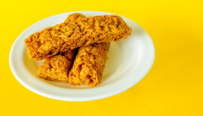 breakfast cereal bars with vitamins on a plate on a yellow background