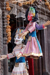 Traditional handmade dolls puppets in colorful clothing on the narrow  street of historical old...