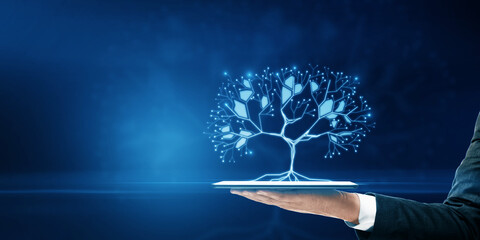 Close up of businessman hand holding tablet with glowing digital polygonal tree on blue background...