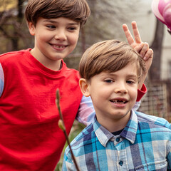 Cute little boys playing on the backyard. 8 years old kid birthday party. Smiling child without front teeth with older brother. Happy blonde-haired toddlers portrait