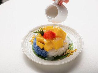 Ripe Mango with Coconut Flavored Sticky Rice on white dish, .Popular Thai desserts,Food and Desserts concept.