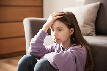 Sad child at home. Abuse. Depression girl indoors. Family problems, misunderstanding of parents,...