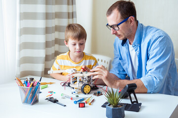 Stem education. School boy male teacher working on project, making diy robot